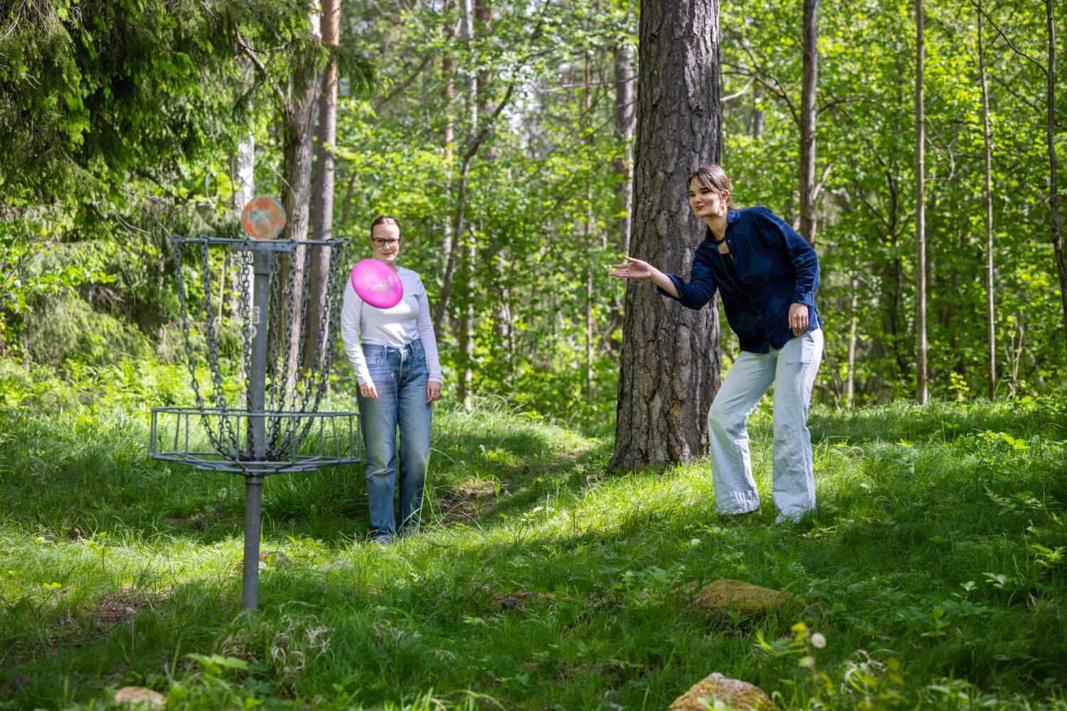Två spelar discgolf